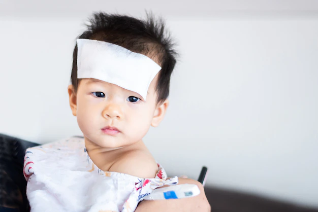 unhappy asian little baby sick with cool fever jel pad forehead 40836 1672.jpg